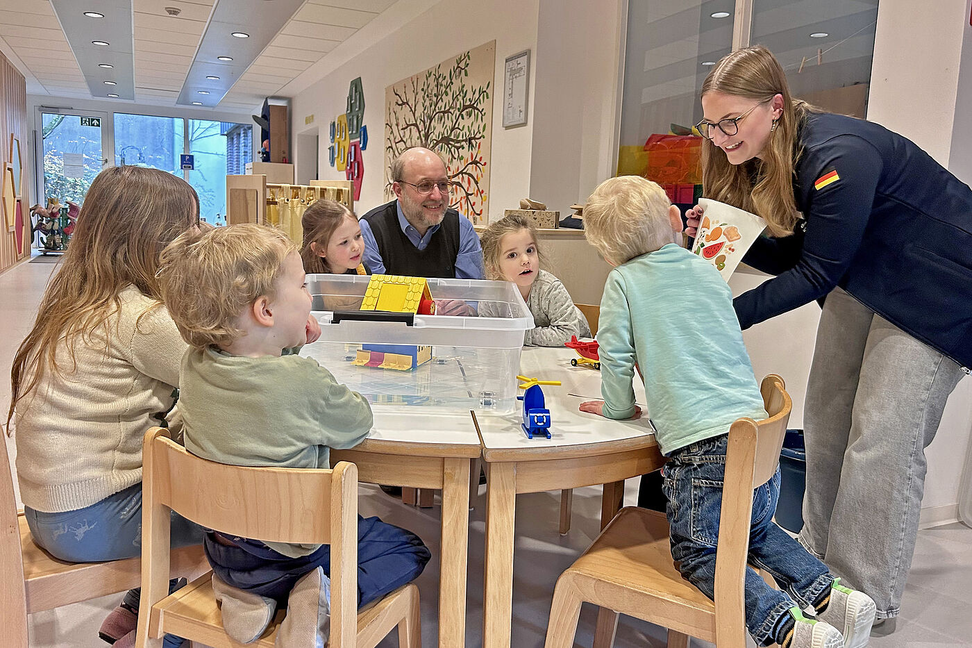 Mehrere Kinder am Tisch und eine Frau