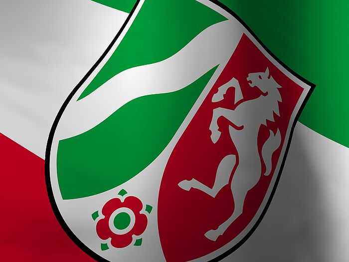 Nahaufnahme des NRW-Wappen auf einer wehenden NRW-Fahne