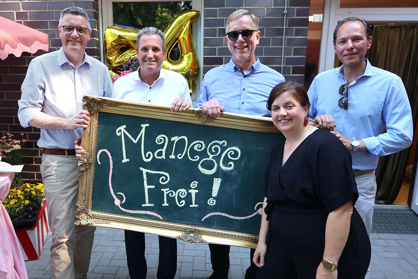 Fünf Leute halten ein Schild mit "Manege frei" hoch