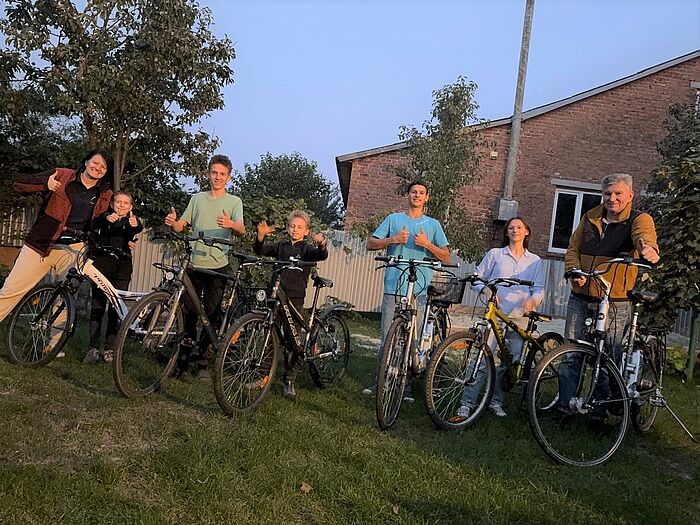 Eine Familie mit Fahrrädern auf einer Wiese.