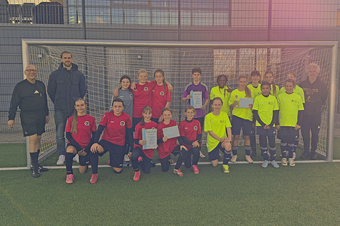 Fußballspielerinnen und ihre Trainer in einem Tor.