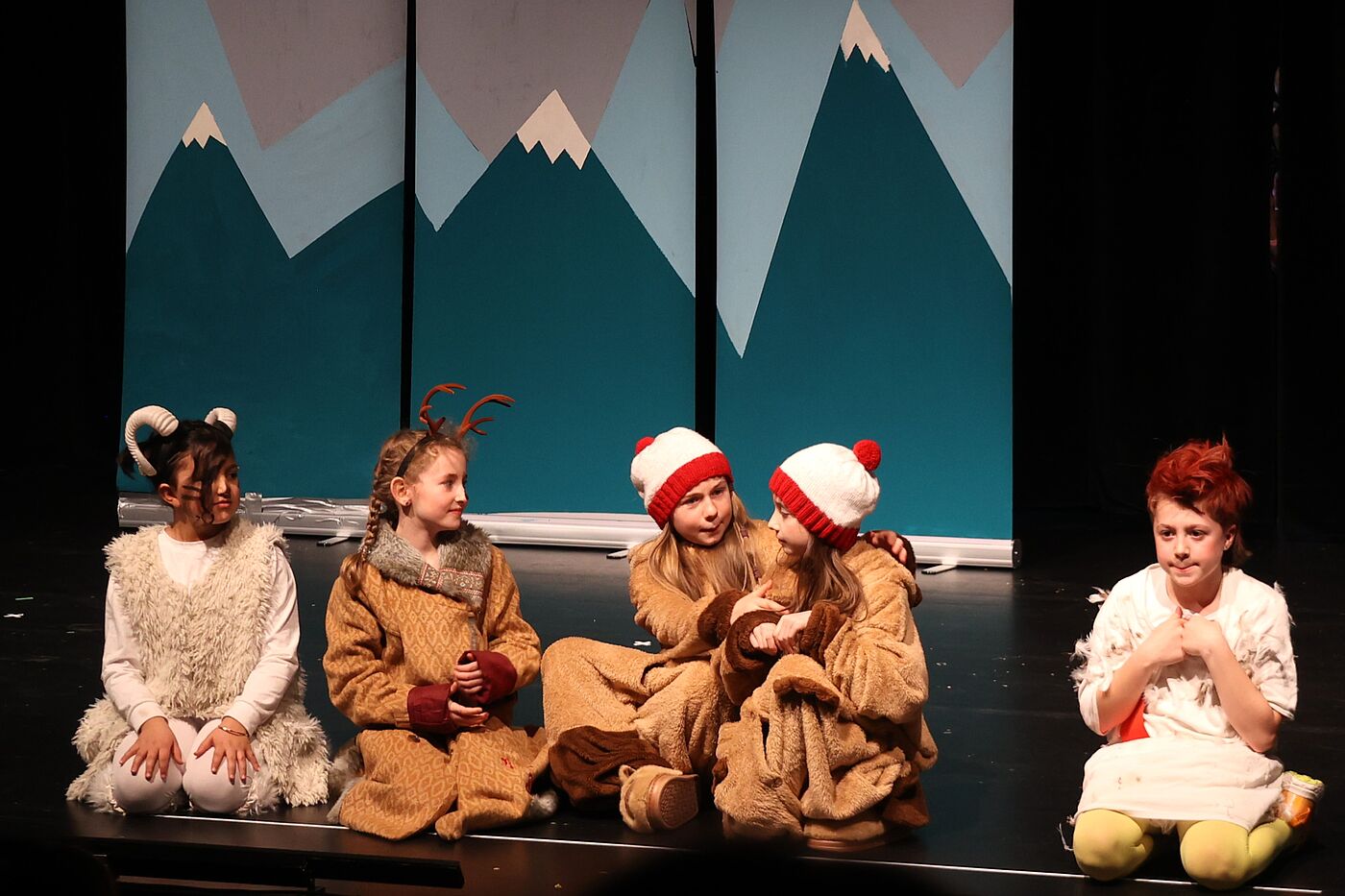 Kinder in Kostümen auf einer Bühne.