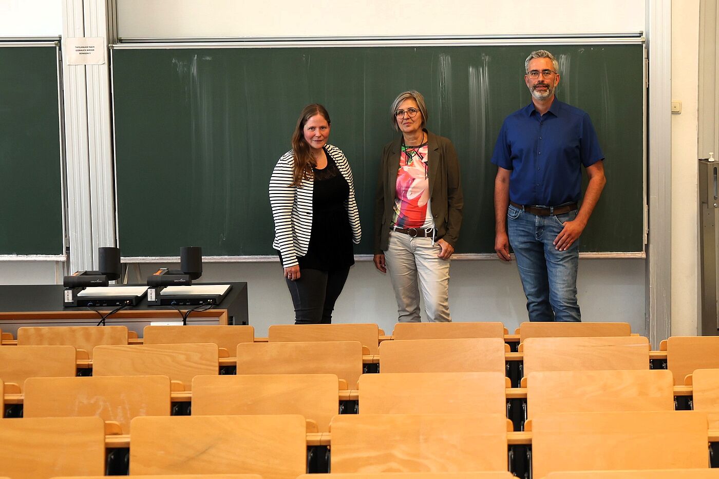 Drei Leute vor einer Tafel