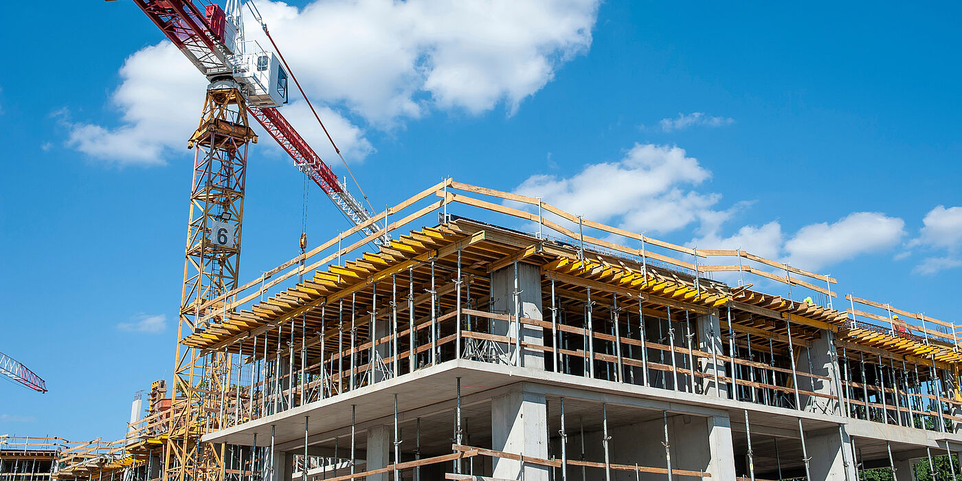Wohnungsbauprojekt im Rohbau mit Kran