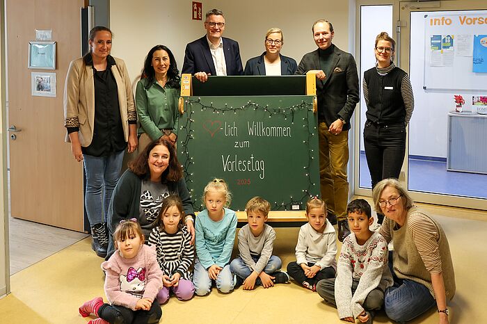 Städteregionsrat Dr. Tim Grüttemeier (hinten 3.v.l.)  und Sebastian Heyn, Leiter des Amtes für Kinder, Jugend und Familie der StädteRegion Aachen (hinten 2.v.r.) haben in der KiTa „Weltentdecker“ in Baesweiler vorgelesen.