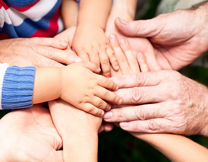 Große und kleine Hände sind übereinander gelegt