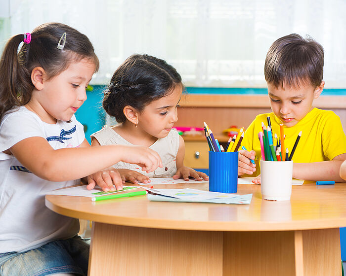 Drei Vorschulkinder malen