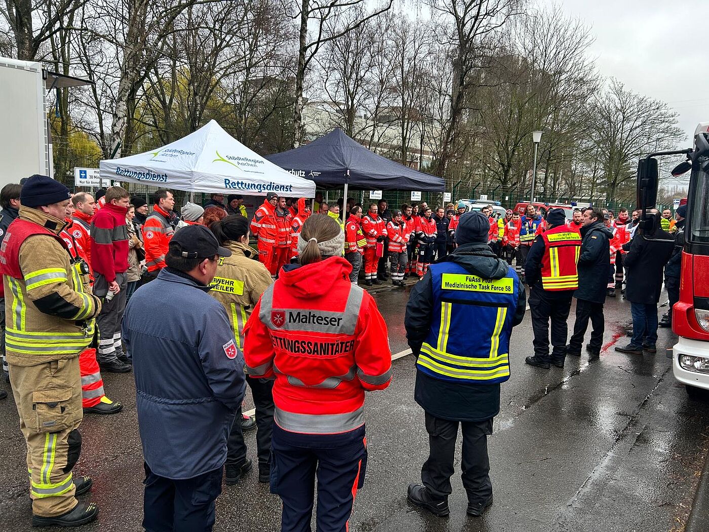 Mehrere Feuerwehr- und Rettungskräfte stehen zusammen.