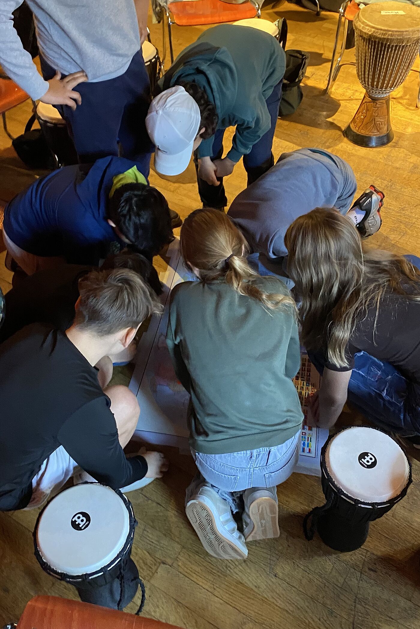 Kinder auf dem Boden zwischen Trommeln