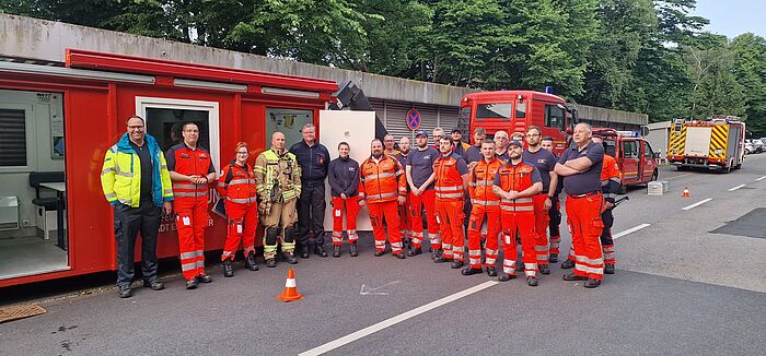 Der Patiententransportzug 10 NRW der StädteRegion Aachen mit Feuerwehrleuten davor.