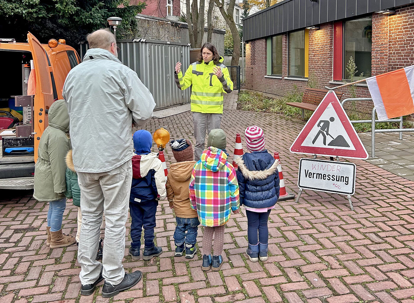 Ein Mann und mehrere Kinder von hinten