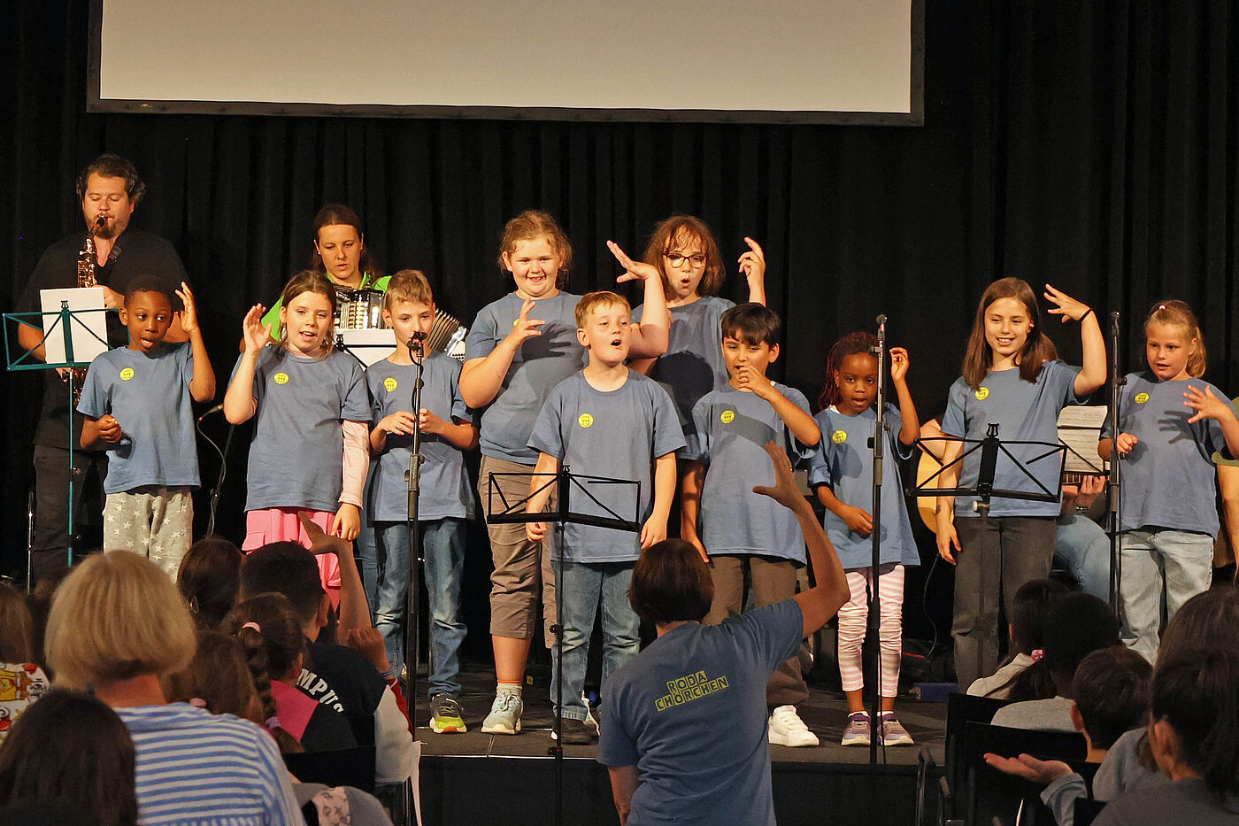 Kinder tanzen auf einer Bühne.