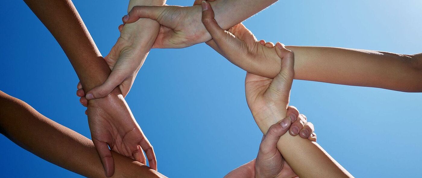 Acht Hände halten sich fest