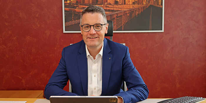 Städteregionsrat Dr. Tim Grüttemeier sitzend hinter seinem Schreibtisch
