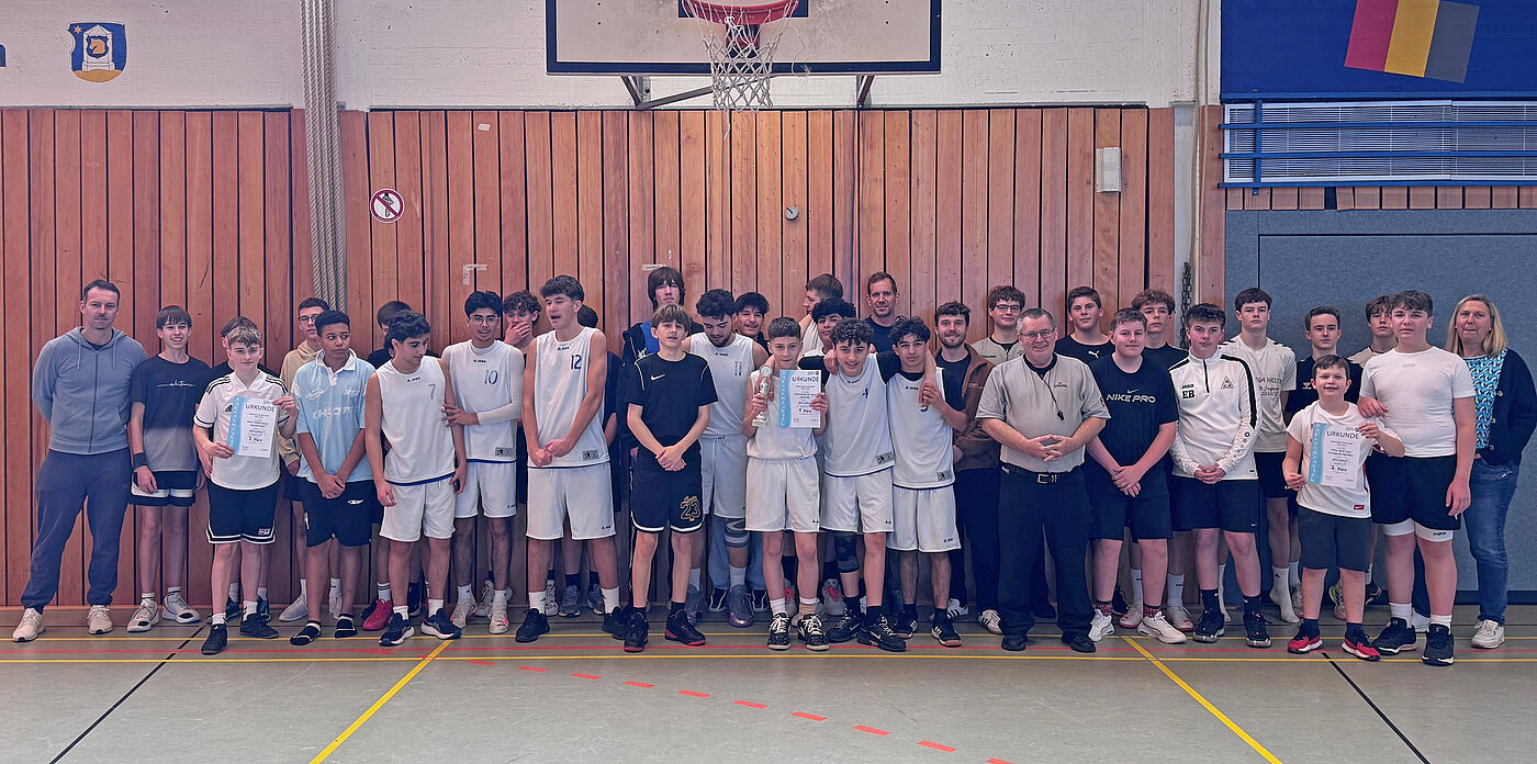 Mehrere Jugendliche unter einem Basketballkorb