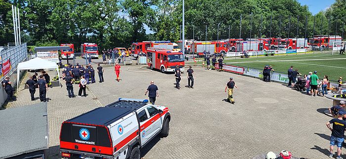 Feuerwehrleute bei einer Übung auf einem Sportplatz.