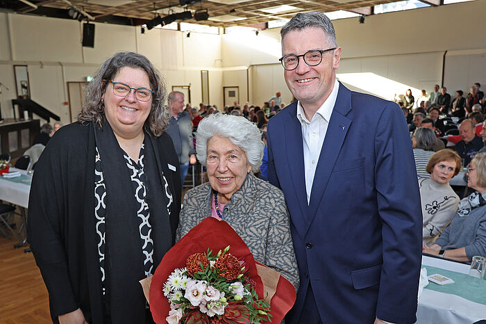 Städteregionsrat Dr. Tim Grüttemeier und die Personalratsvorsitzende, Christina Franzten (l.), überreichten Anna-Maria Kaster (87 Jahre, ehemals Gesundheitsamt) als ältester Teilnehmerin einen Blumenstrauß.