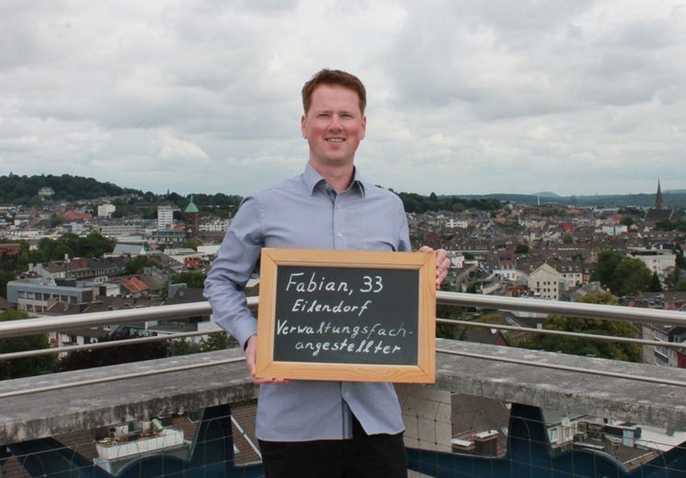 Fabian hält eine Tafel mit seinem Namen, Alter und seinem Ausbildungsberuf