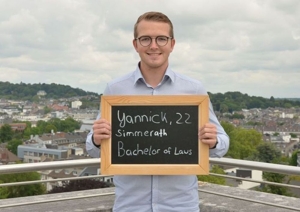 Yannick hält eine Tafel mit seinem Namen, Alter und seinem Ausbildungsberuf