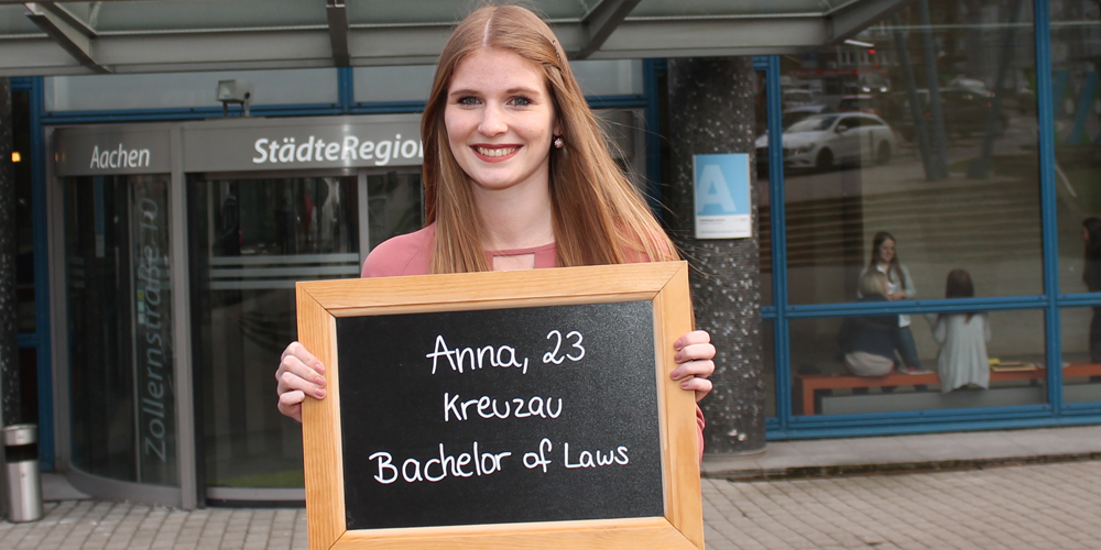 Anna Schmitz hält Tafel mit ihrem Namen, ihrem Alter und ihrem Ausbildungsberuf