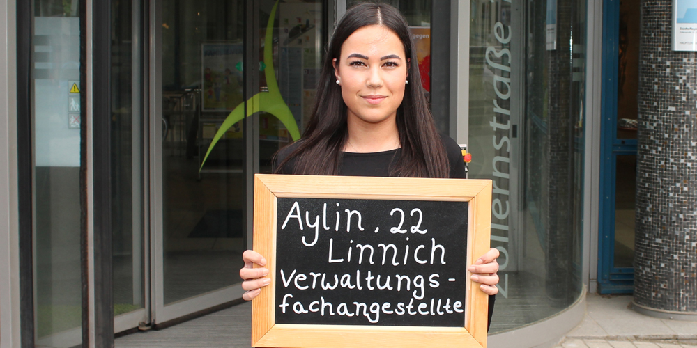 Aylin-Ayla Avci hält Tafel mit ihrem Namen, ihrem Alter und ihrem Ausbildungsberuf