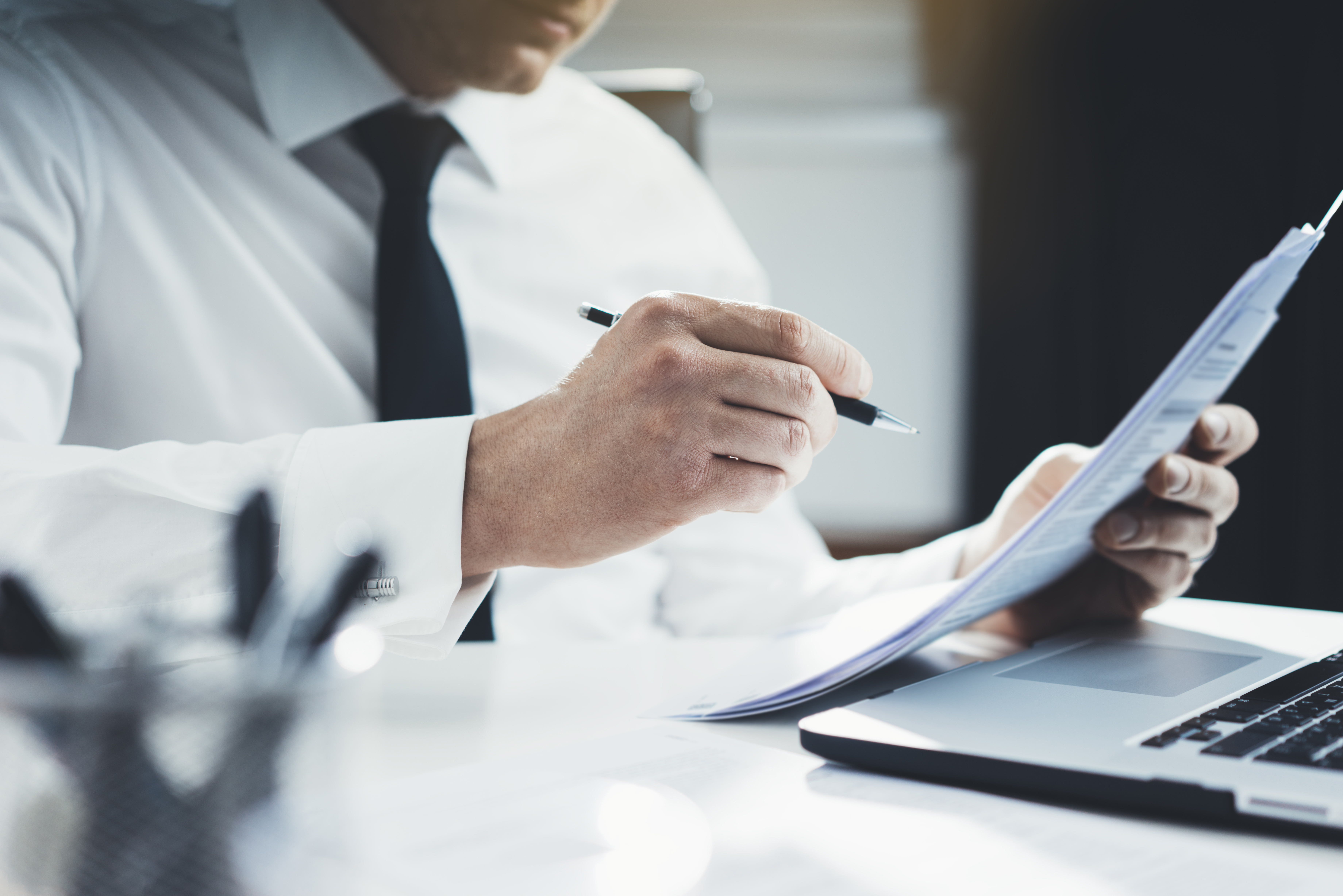 Close-up of professional businessman working at his office with documents...