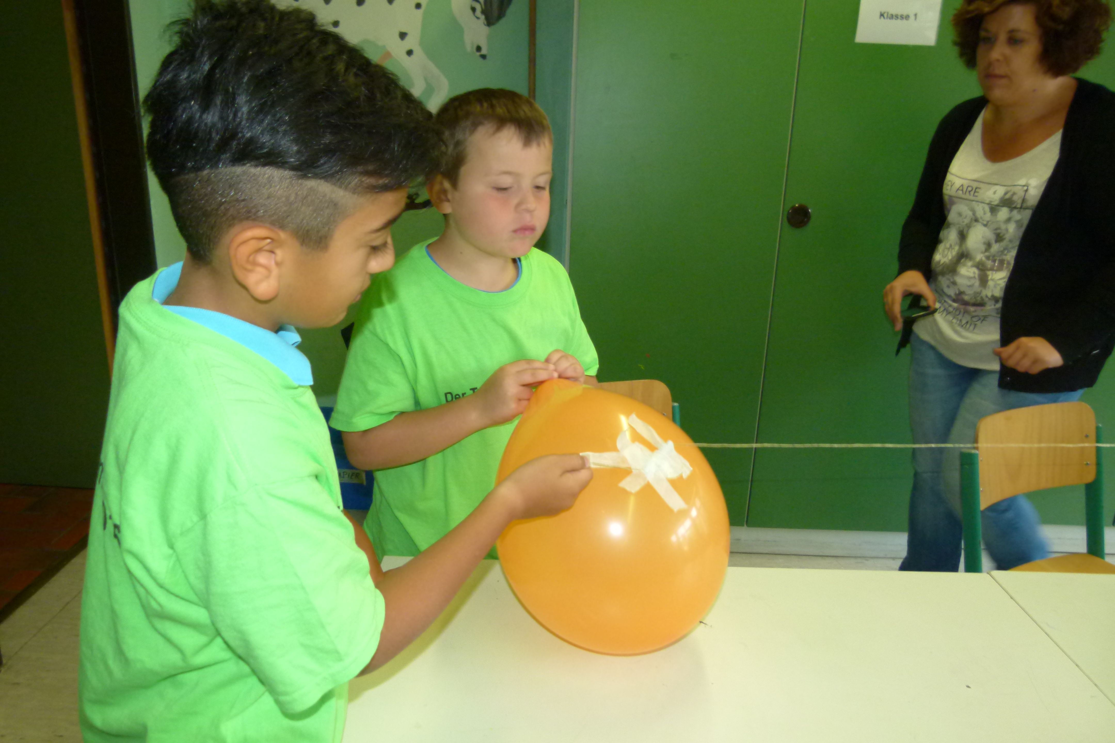 Kinder beim Experientieren mit einem Luftballon