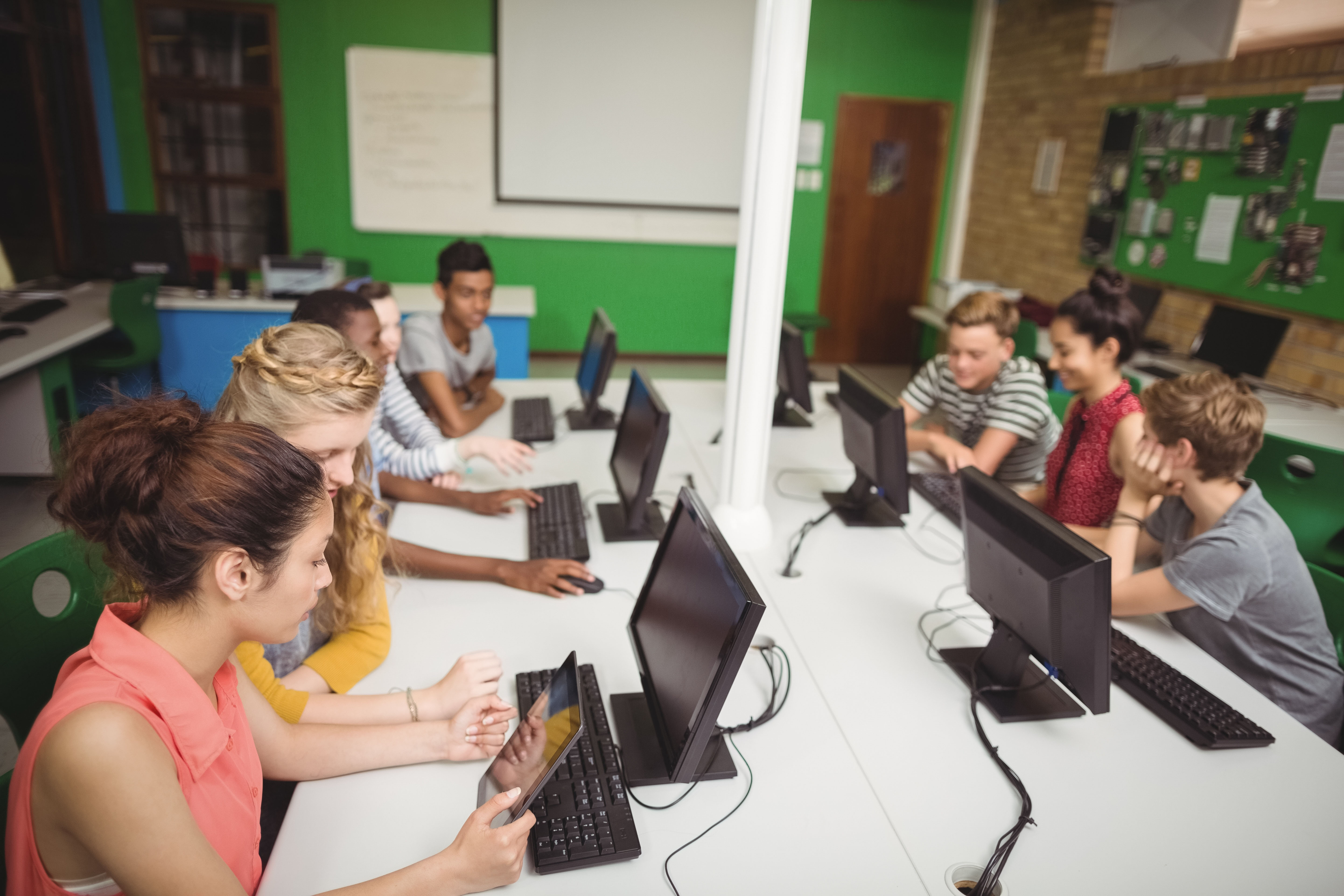 Schüler_innen arbeiten an Computern in Klassenzimmer.