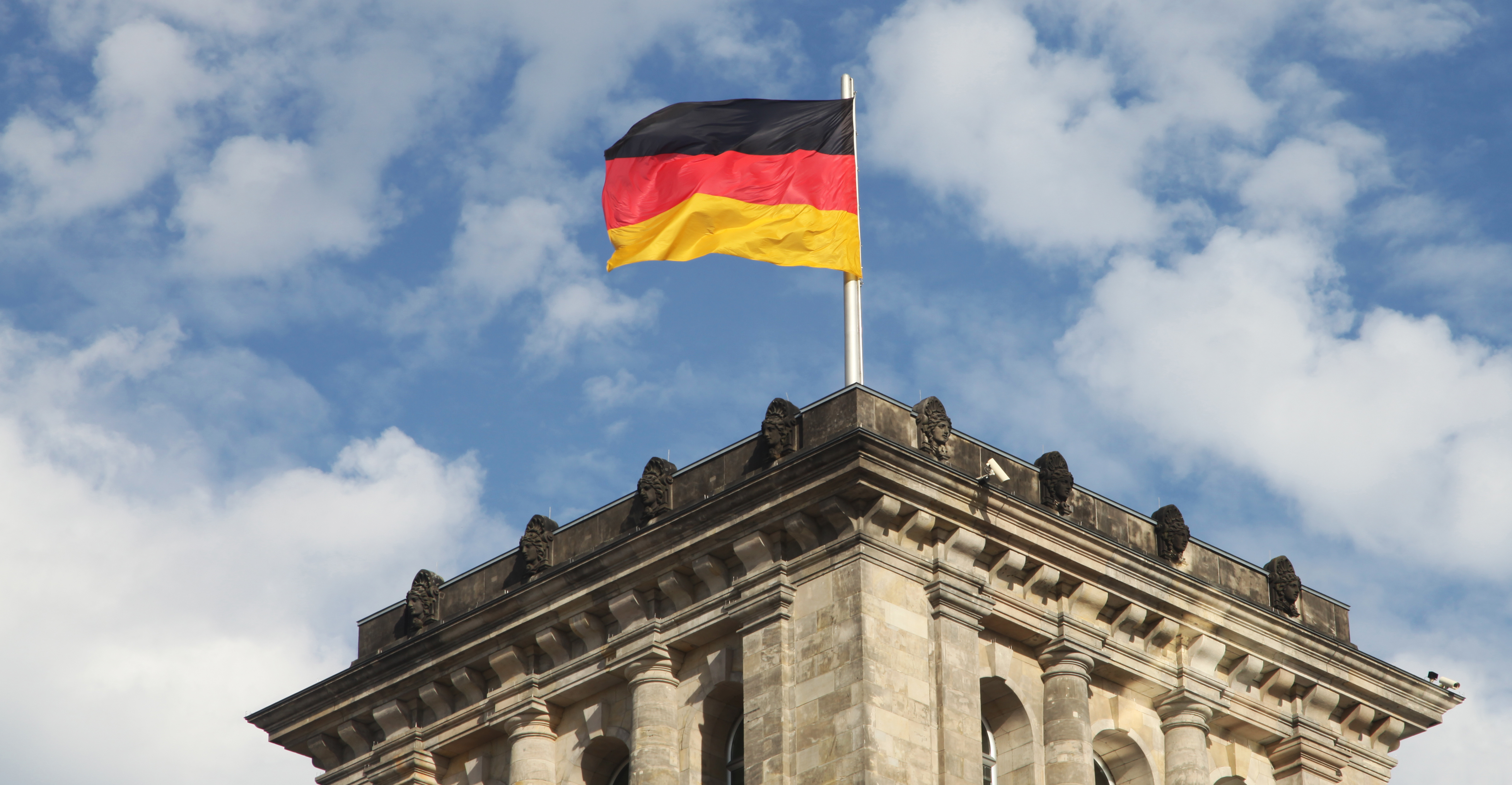 ein kleiner Ausschnitt eines Ministeriumgebäudes mit Deutschlandfahne 