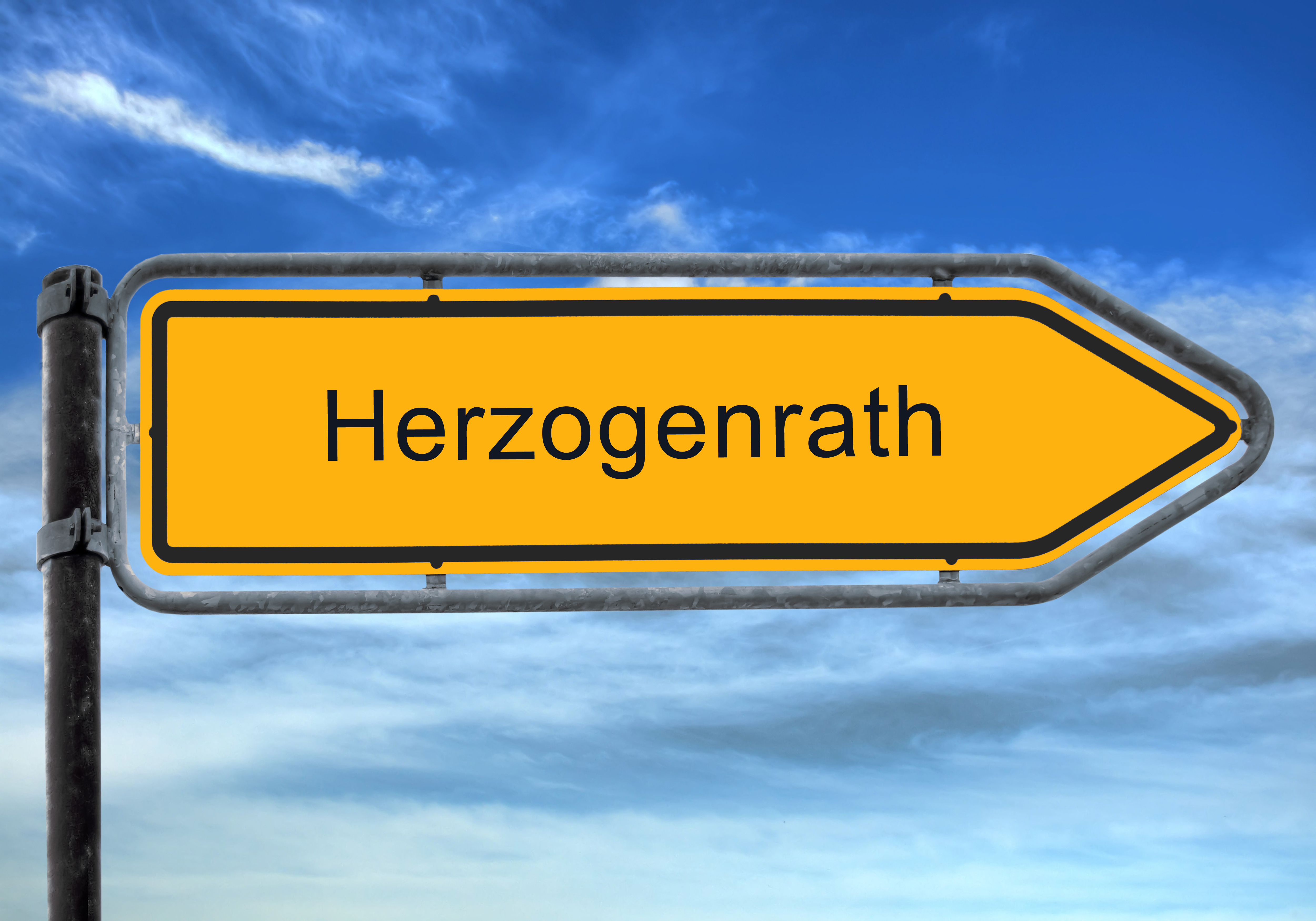 Ortsschild in Pfeilform zeigt Richtung Herzogenrath