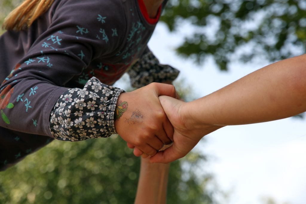 Eine Kinderhand wird von einer Hand eines Erwachsenen gehalten