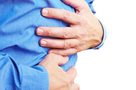 Probleme mit Magen--Darm? Zwei Hände werden vor den Bauch gehalten als ob der Magen schmerzt