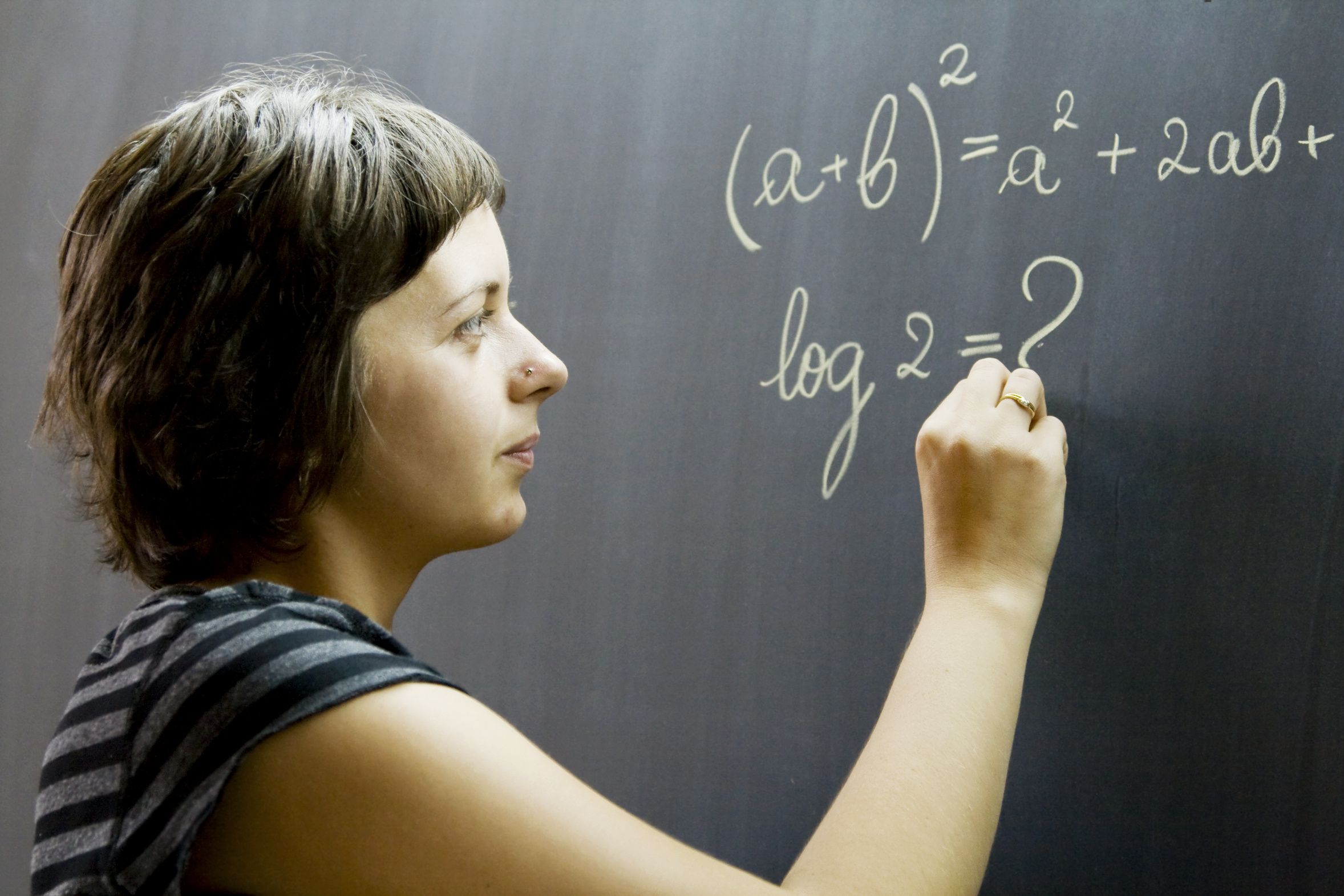 Frau schreibt Formel an die Tafel