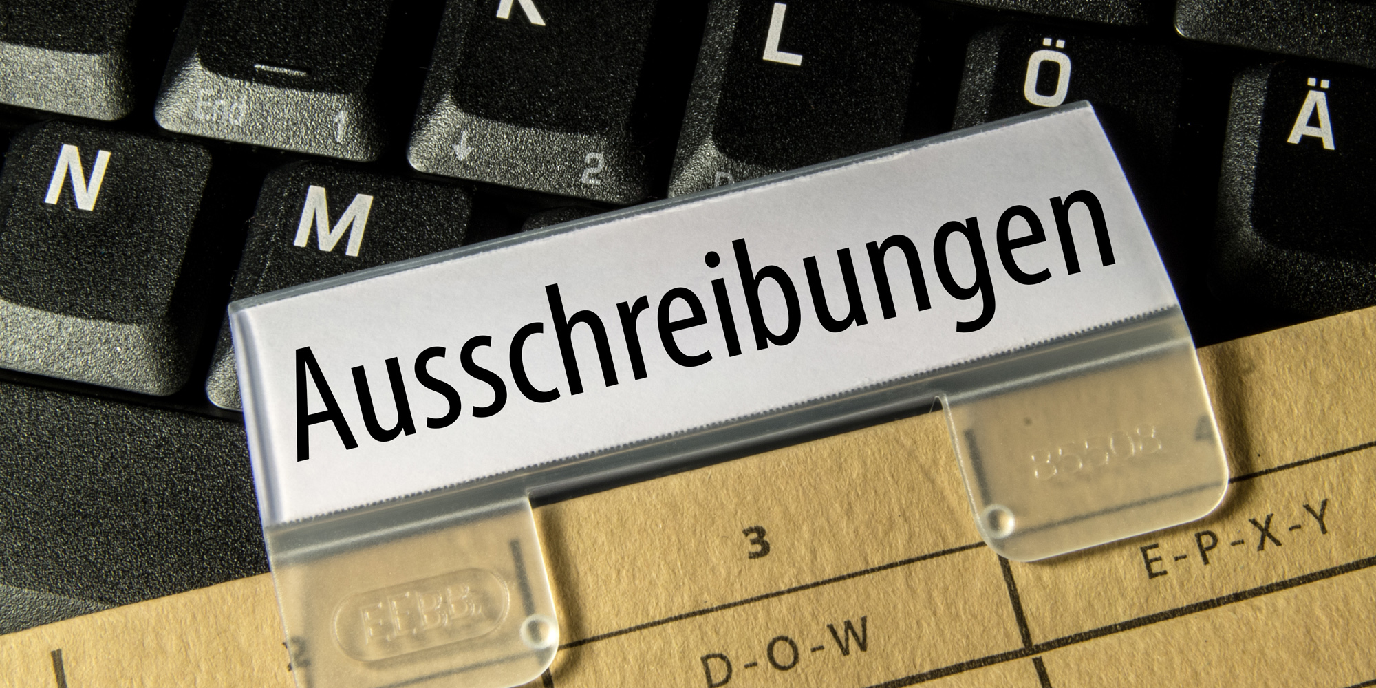 Tastatur mit Akte "Ausschreibungen"