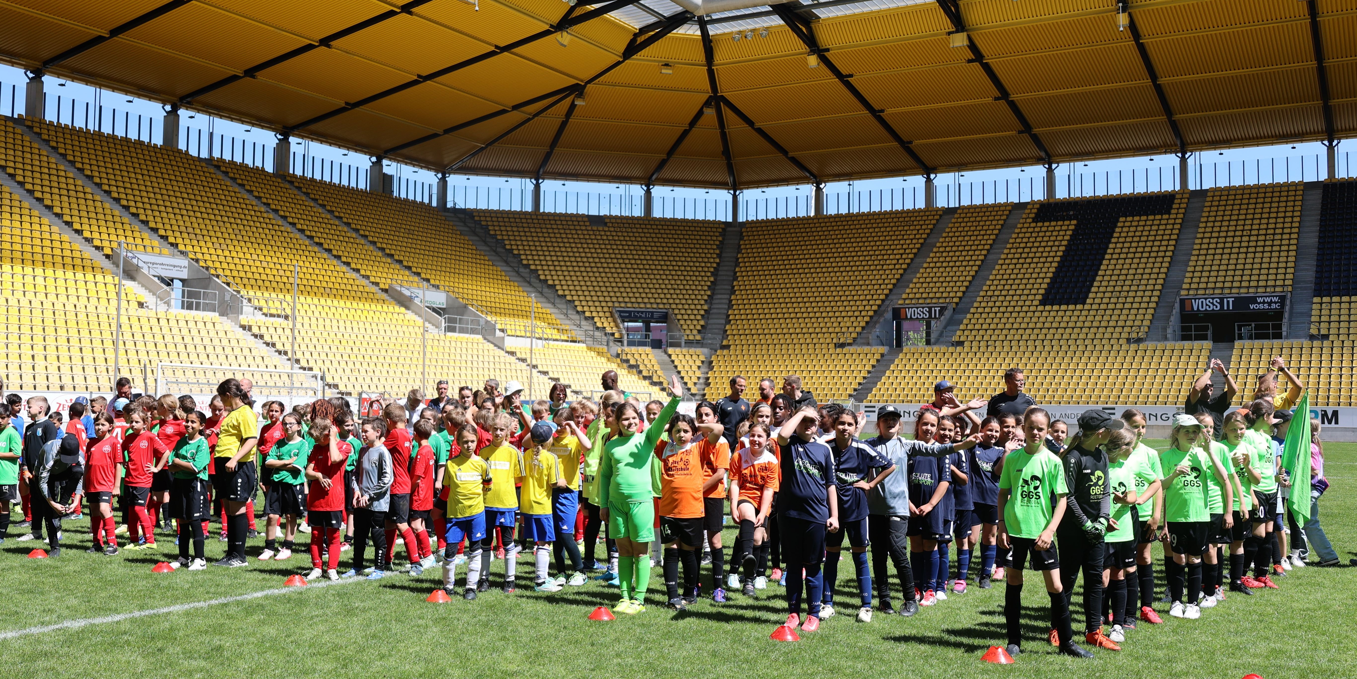 Hunderte Kinder auf dem Rasen eines Fußballstadions