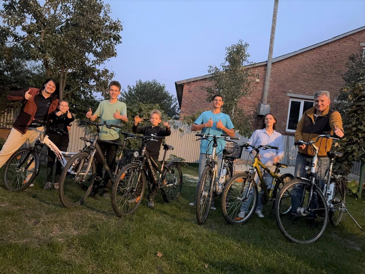 Eine Familie mit Fahrrädern auf einer Wiese.