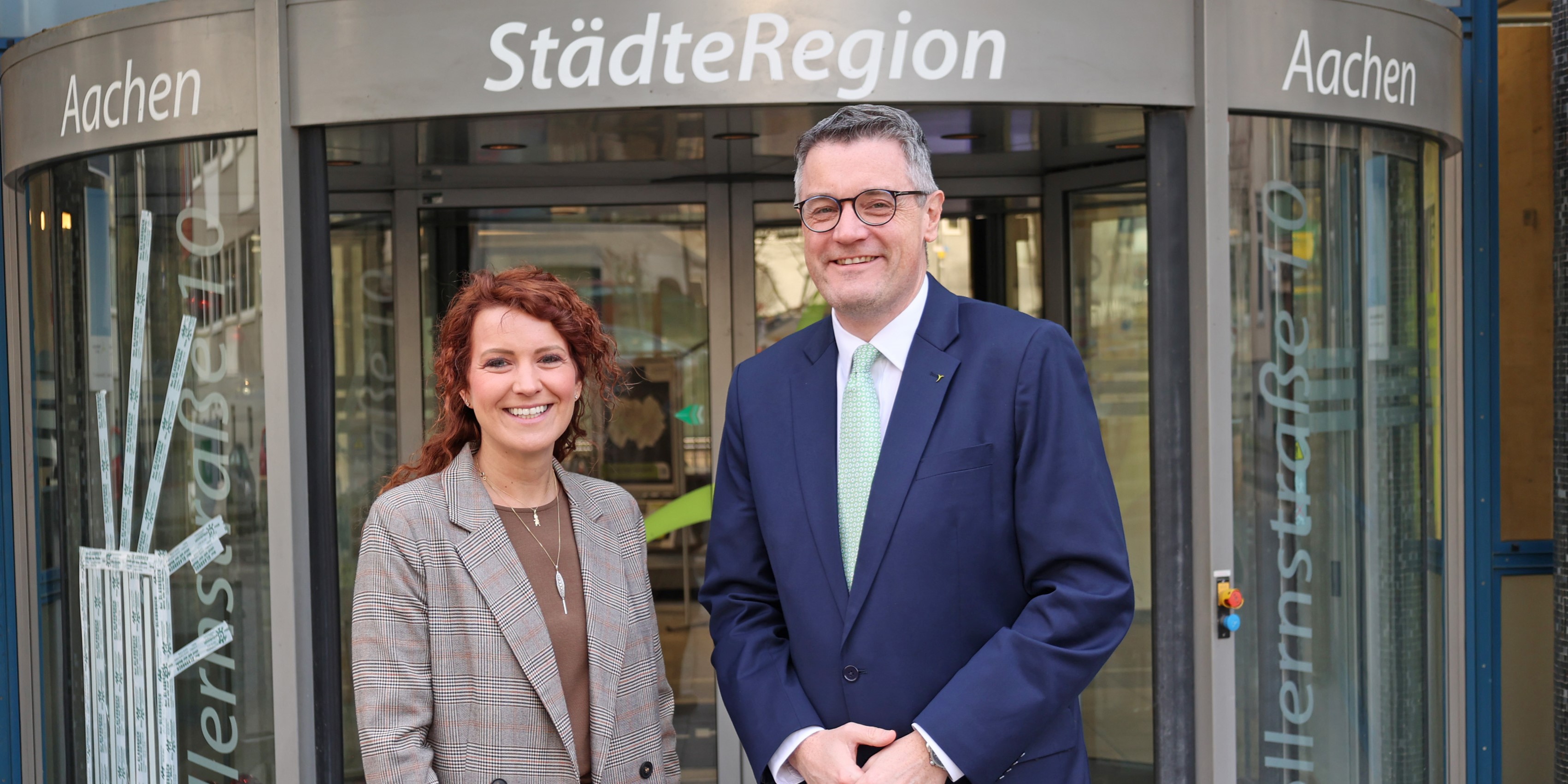 Eine Frau und ein Mann vor einer Glastür.