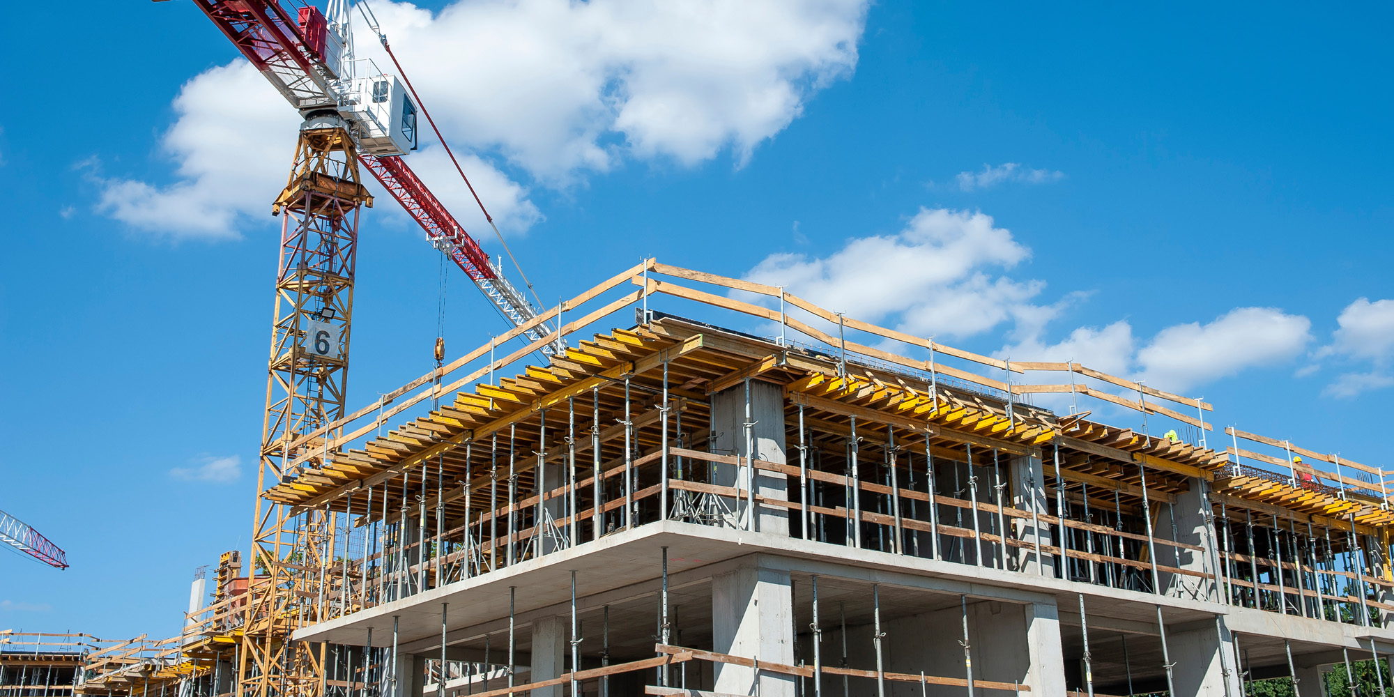 Wohnungsbauprojekt im Rohbau mit Kran